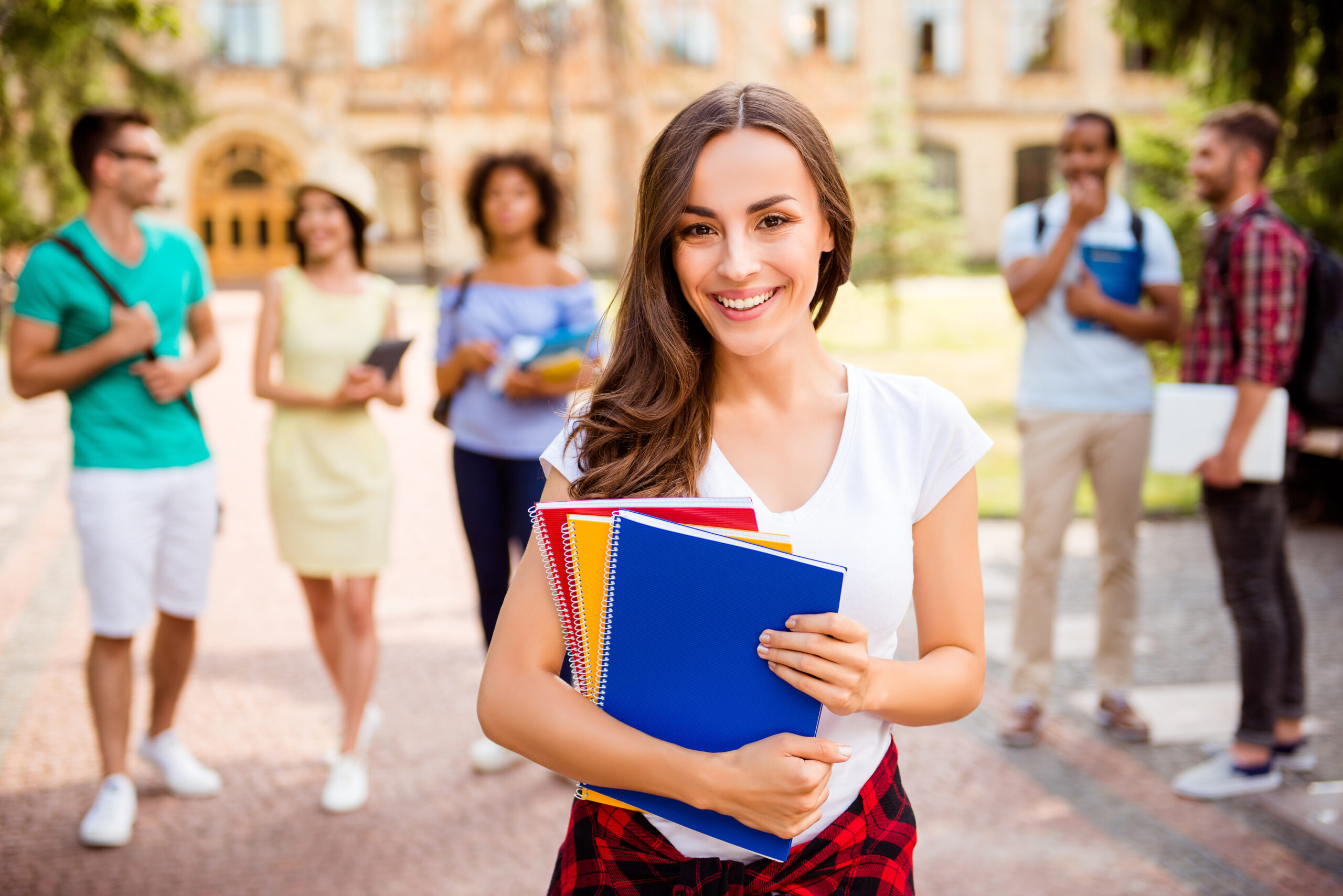 college girl with books with friends in back