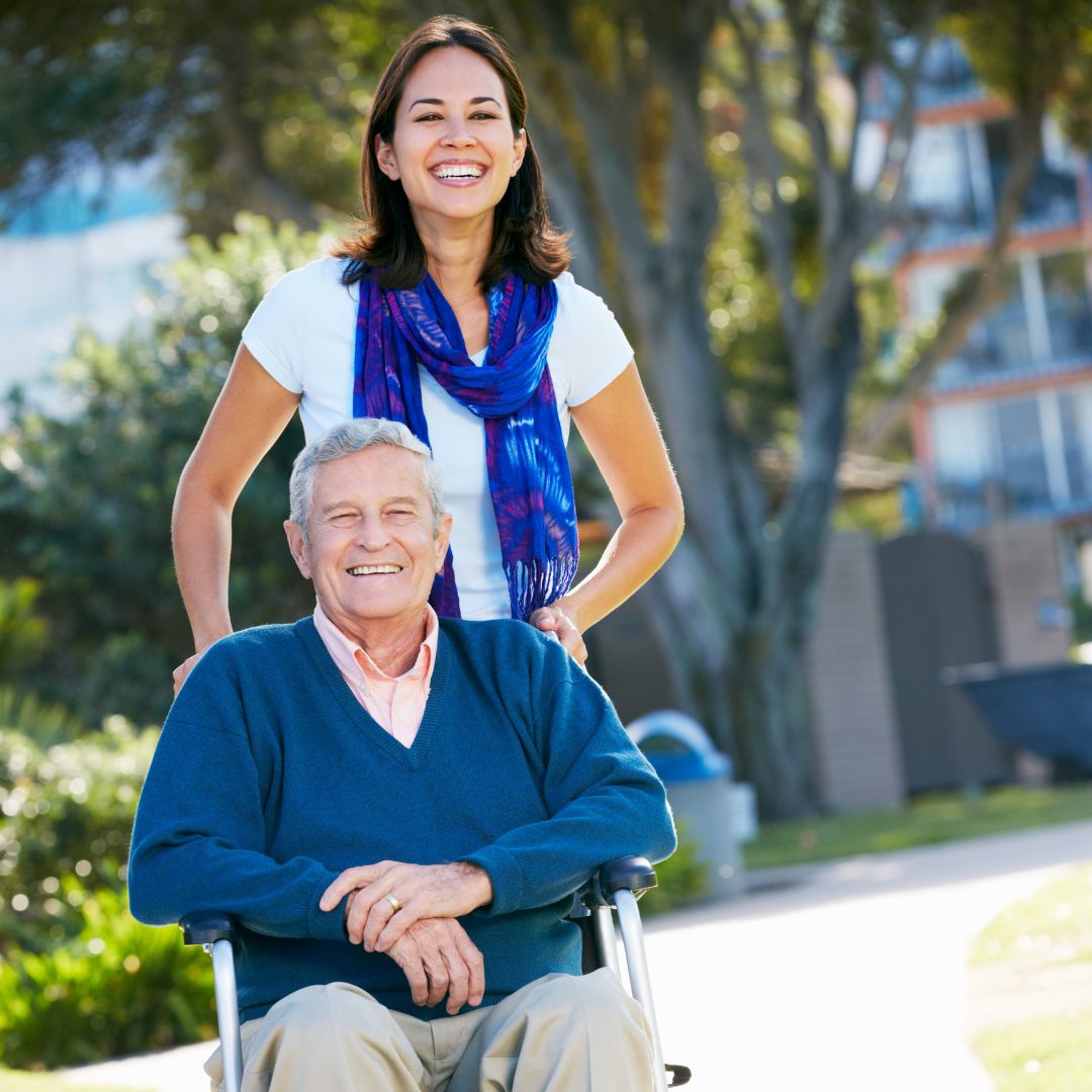 daughter pushing older father in wheelchair