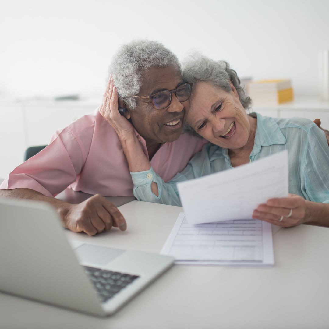 smiling older couple looking at paperwork